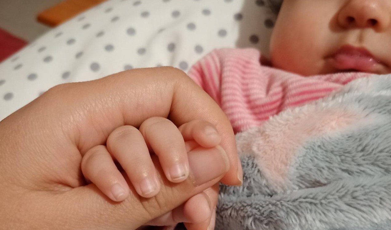 Madre dando la mano a su bebé./ E.R.